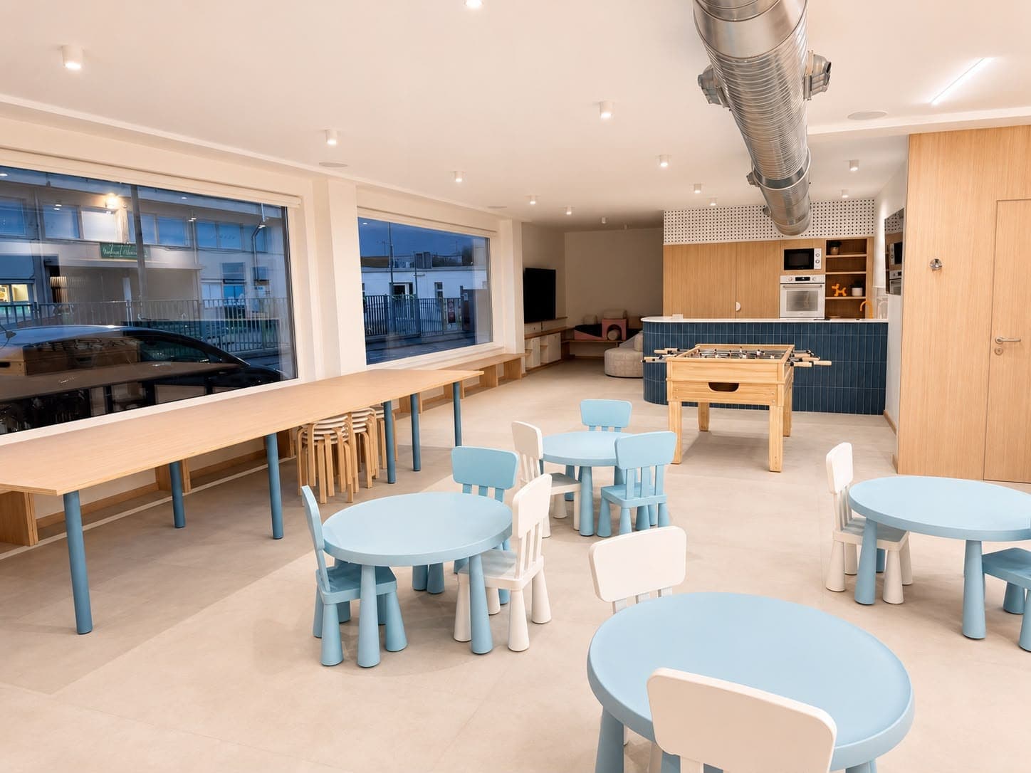 Comedor con mesas infantiles y mesa amplia para adultos